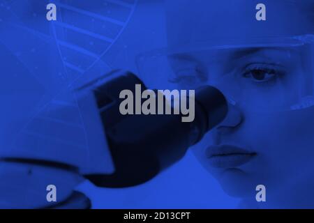 Young female scientist looking through a microscope in a laboratory doing research, microbiological analysis, medicine. Stock Photo