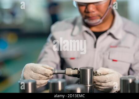 Worker use outside micrometer inspection high product in the production line Stock Photo