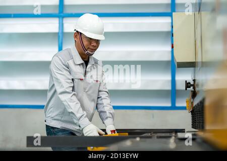 The worker operates the bending machine in the construction machine factory Stock Photo