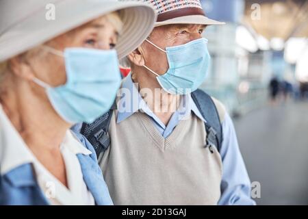 Two elderly people in face masks looking away Stock Photo