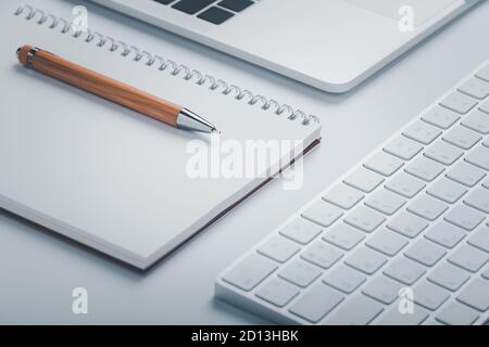 Closeup shot of brown pen with notebook and keyboard on workspace. Stock Photo