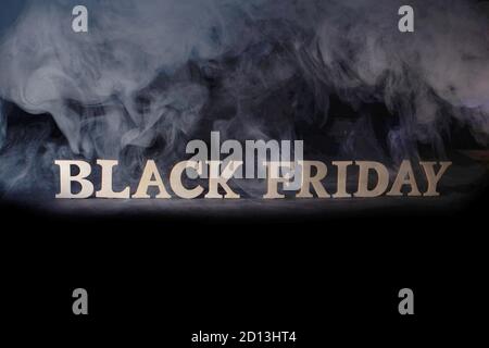 The inscription black friday in gold letters on a black background in smoke. Concepts for profitable purchases and sales in stores, shopping Stock Photo