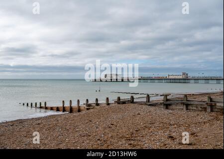 Looking west to Worthing Pier over the beach with wooden groynes spaced out to protect against sea erosion. West Sussex, UK. Stock Photo