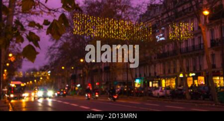 Blurred photo of Christmas lights in Paris, France. Boulevard Beaumarchais decorated with festive illumination.  Road traffic. Winter holidays travel Stock Photo