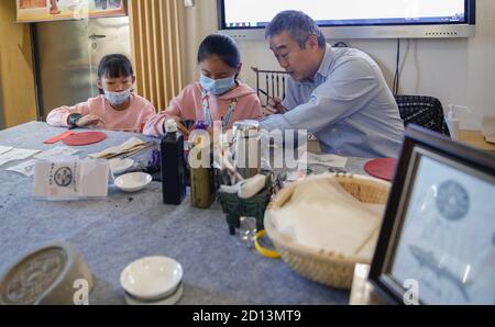 Beijing, China. 5th Oct, 2020. Children experience rubbing of ancient coins at a science and culture experience center in Beijing, capital of China, on Oct. 5, 2020, the fifth day of National Day and Mid-Autumn Festival holiday. Credit: Zhang Yuwei/Xinhua/Alamy Live News Stock Photo