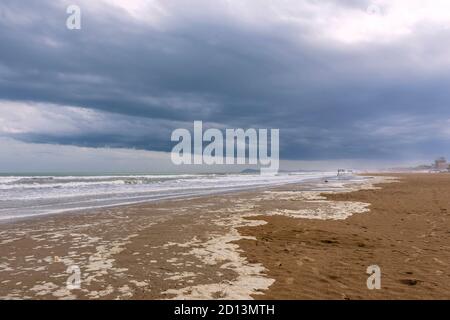 The long and wide beach of Rimini, Emilia Romagna, Italy, under a dramatic sky in the winter season Stock Photo