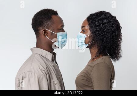 Man and woman in face masks looking at each other Stock Photo