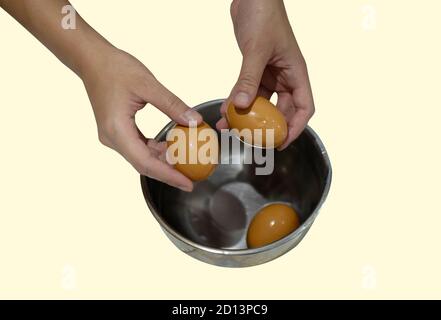 The boiled egg was being shelled  by the woman's hand. Stock Photo