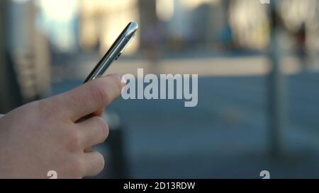 Hipster man hands using his smartphone outdoor in the park. Stock Photo