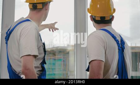 Supervisor showing something to colleague at construction site. Stock Photo
