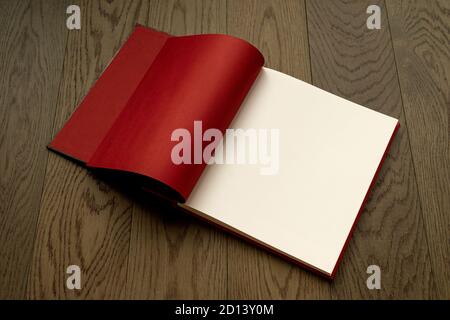 Open book on wooden table with red and white empty pages. Booklet, magazine mock up for any design or advertising Stock Photo