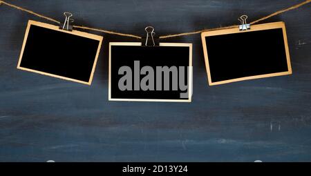 Empty photo frames hanging on dark grungy background, space for your pictures Stock Photo