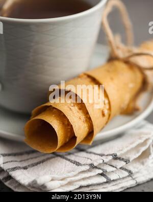 Thin homemade Apple pastille close-up. A healthy snack on a saucer next to a mug of tea. Stock Photo