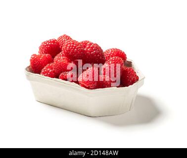 Tiny box with raspberries, (approx 250 gram) on a white table. Stock Photo