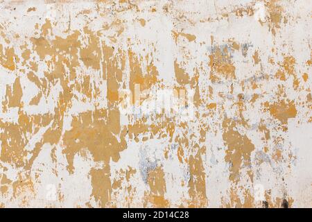 Shabby flat plaster and painted wall with big yellow under layer spots Stock Photo