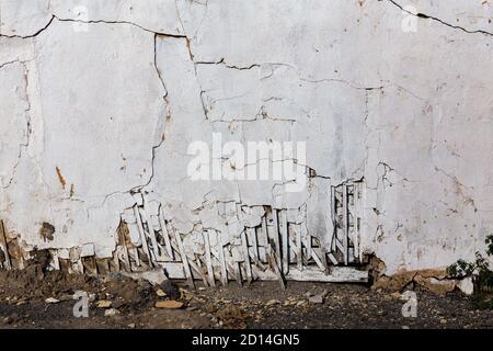 poor wattle and daub cracked stucco wall with white plaster Stock Photo