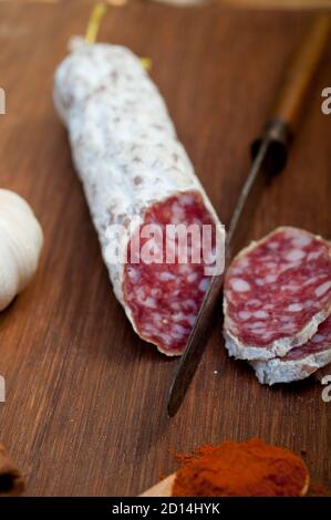 traditional Italian salame cured sausage sliced on a wood board Stock Photo