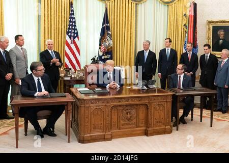 President Trump Participates in a Signing Ceremony. President Donald J. Trump listens as Vice President Mike Pence delivers remarks at a signing ceremony with Serbian President Aleksandar Vučić and Kosovo Prime Minister Avdullah Hoti Friday, Sept. 4, 2020, in the Oval Office of the White House. Stock Photo