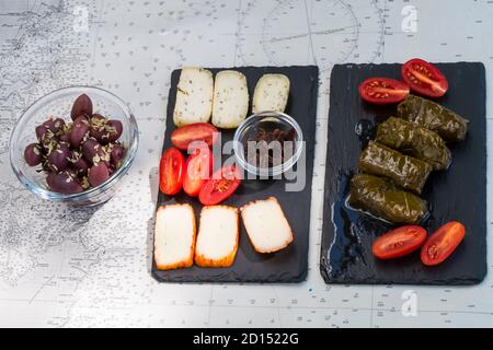 Dolma, delicious Casucasian and Turkish cuisine, vine leaves stuffed with minced meat and rice. Plates with different tasty fresh cheese and isolated Stock Photo