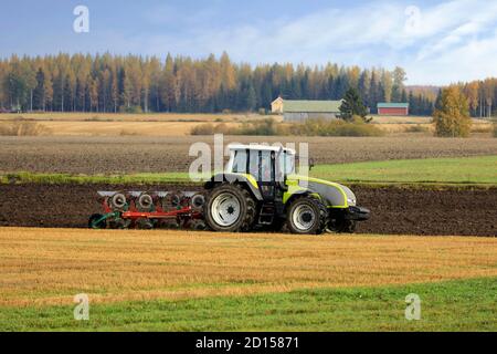 Farmer plows field with green Valtra tractor and plough on a sunny autumn morning in South of Finland. Jokioinen, Finland. October 2, 2020 Stock Photo