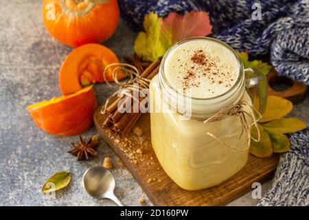 Autumn pumpkin spiced latte or coffee in glass with organic ingredients on a light stone countertop. Stock Photo