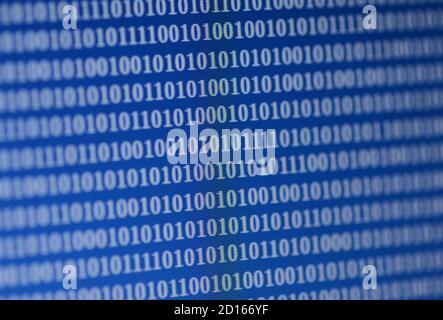 Binary digits displayed on a computer screen. The pattern of 0s and 1s encrypts information in network and communication systems. Stock Photo