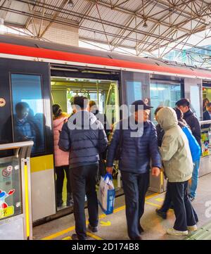 SHANGHAI, CHINA - DEC 28, 2016: People boarding train at Shanghai Metro station. Shanghai Metro operating urban and suburban rail transit services to Stock Photo