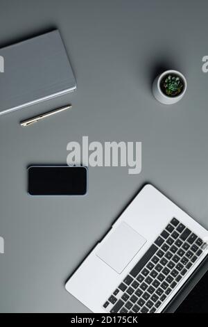 Above view flat lay of laptop and business gadgets on grey workplace background, copy space Stock Photo