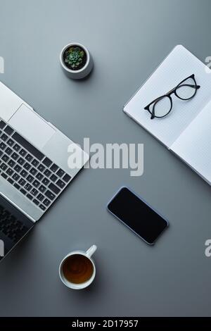 Above view business flat lay of laptop and smartphone on grey workplace background with coffee cup, copy space Stock Photo