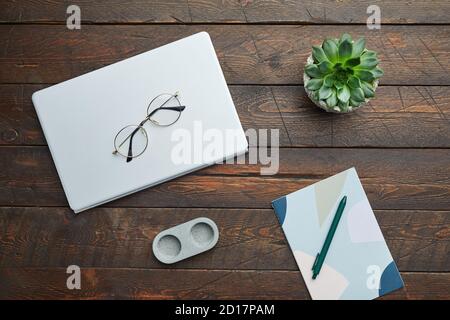 Minimal above view flat lay of business accessories glasses and succulent over wooden workplace background, copy space Stock Photo