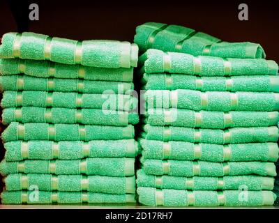 Light green identical terry towels stacked in piles in the store Stock Photo