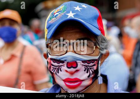 Caracas, Venezuela. 05th Oct, 2020. A woman wearing a double face mask and a cap in the colours of the Venezuelan flag takes part in a protest by teachers and nurses for better working conditions in the middle of the Corona pandemic. Opposition leader Guaido supported the call. According to official figures, 78,434 people infected with Covid-19 and 653 coronavirus deaths have been confirmed in Venezuela. The country was already in a deep economic and political crisis before the corona pandemic. Credit: Pedro Rances Mattey/dpa/Alamy Live News Stock Photo