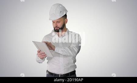 Construction specialist using a tablet computer while walking on Stock Photo