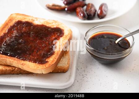 Fresh toasts with dates jam without sugar on white table. Close up. Stock Photo