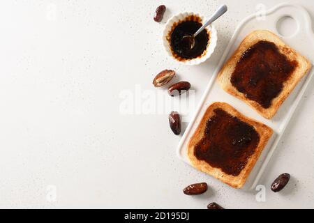 Fresh toasts with dates jam without sugar on white table. Spac for text. View from above. Stock Photo