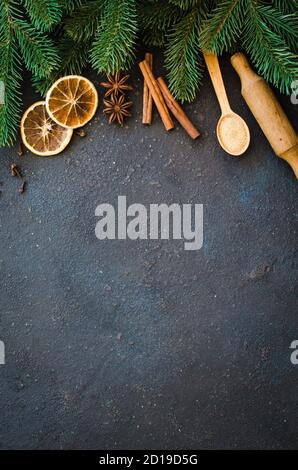 Christmas culinary background for menu or recipe. Spices for baking and fir branches on concrete. Stock Photo