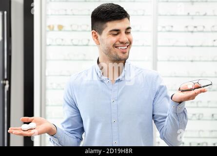 Thinking man choosing between eyeglasses and contacts Stock Photo