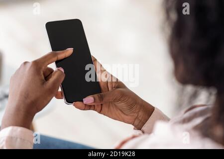 Unrecognizable African American Female Browsing Smartphone With Black Screen, Mockup Image Stock Photo