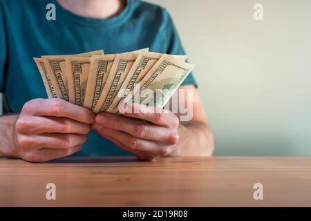 Person counting US dollar bills Stock Photo