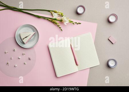 Minimal composition of blank planner over pink graphic background with floral decor, copy space Stock Photo