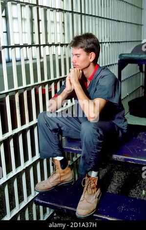 Teen male sits in jail after being sentenced for a crime Stock Photo