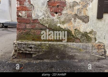 destroyed brick wall with fallen off plaster. Stock Photo