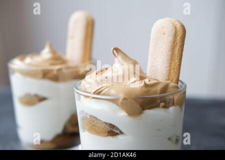 Iced frothy Dalgona Coffee tiramisu, a trendy fluffy creamy whipped coffee on the top of tiramisu dessert. Korean drink latte espresso with coffee foam. close up view Stock Photo