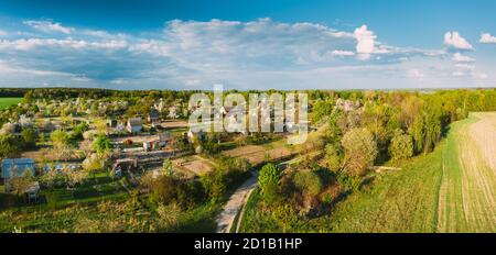 Countryside Rural Landscape With Small Village, Gardens And Green Field In Spring Summer Day. Elevated View. Panorama Stock Photo