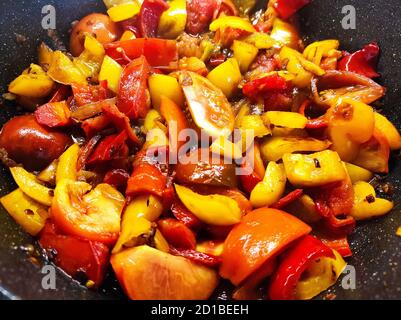 Spicy vegetable stew of tomatoes, lentils, onions, bell peppers and carrots close-up in pan. Top view. Delicious vegetarian organic home ragout cookin Stock Photo