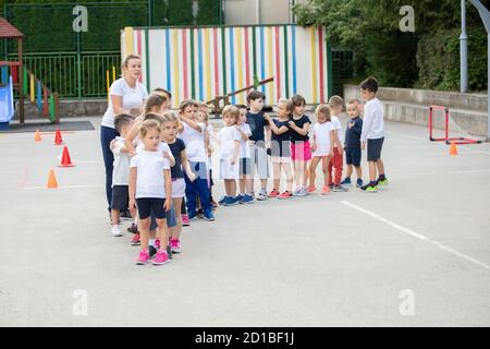 Group of children standing in column and waiting for lesson start.  Sport school Stock Photo