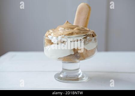 Iced frothy Dalgona Coffee tiramisu, a trendy fluffy creamy whipped coffee on the top of tiramisu dessert. Korean drink latte espresso with coffee foam. Stock Photo