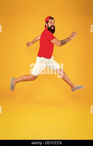 Always in motion. Enjoying active lifestyle. Happy guy jumping. Active bearded man in motion yellow background. Active and energetic hipster. Energy charge. Healthy guy feeling good. Inspired concept. Stock Photo