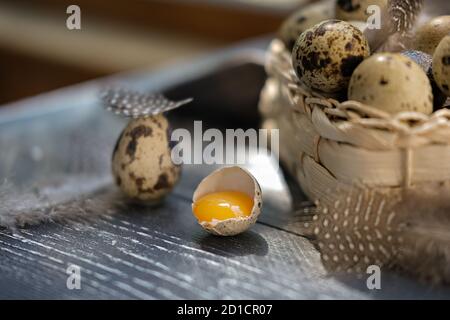 organic farmer quail eggs in woven basket and on wooden table. rustic style. egg yolk in a shell. high lecitine and high proteins meal. Stock Photo