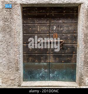 Wooden door of a cantina where food is stored in a cool place. Culinary tour on Lake Lugano in Ticino, Circolo di Carona, Switzerland Stock Photo